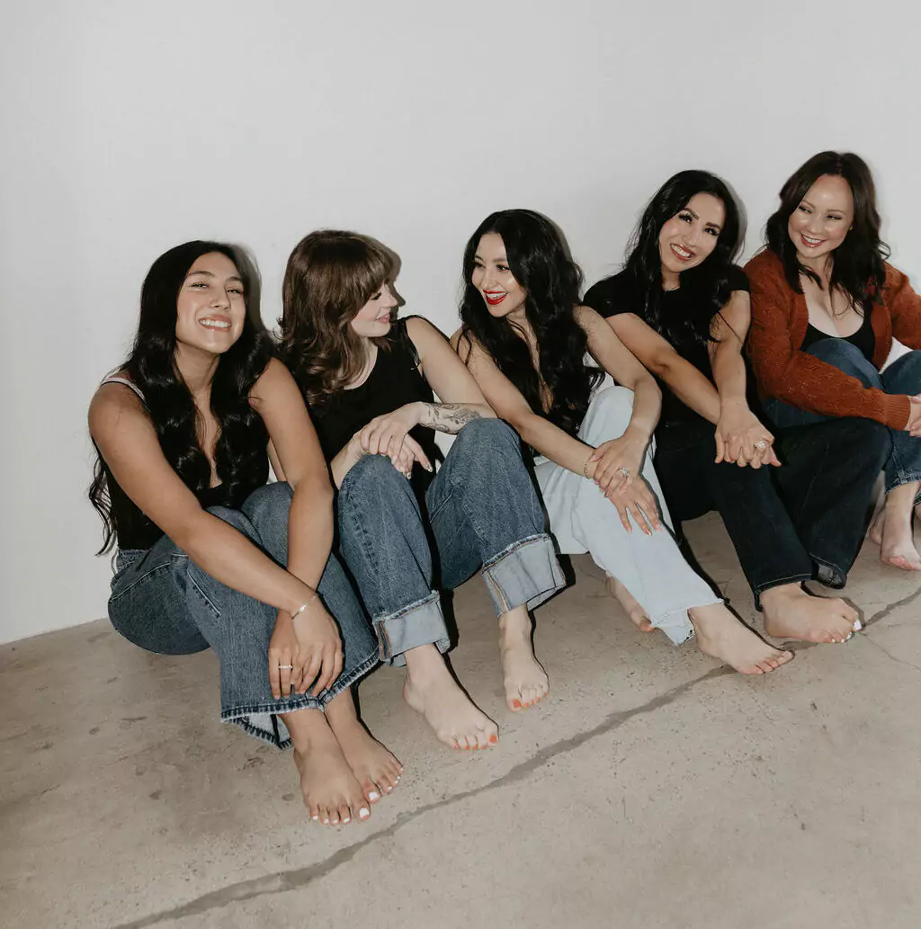 The Beauty Lab team talking and laughing together sitting on the ground
