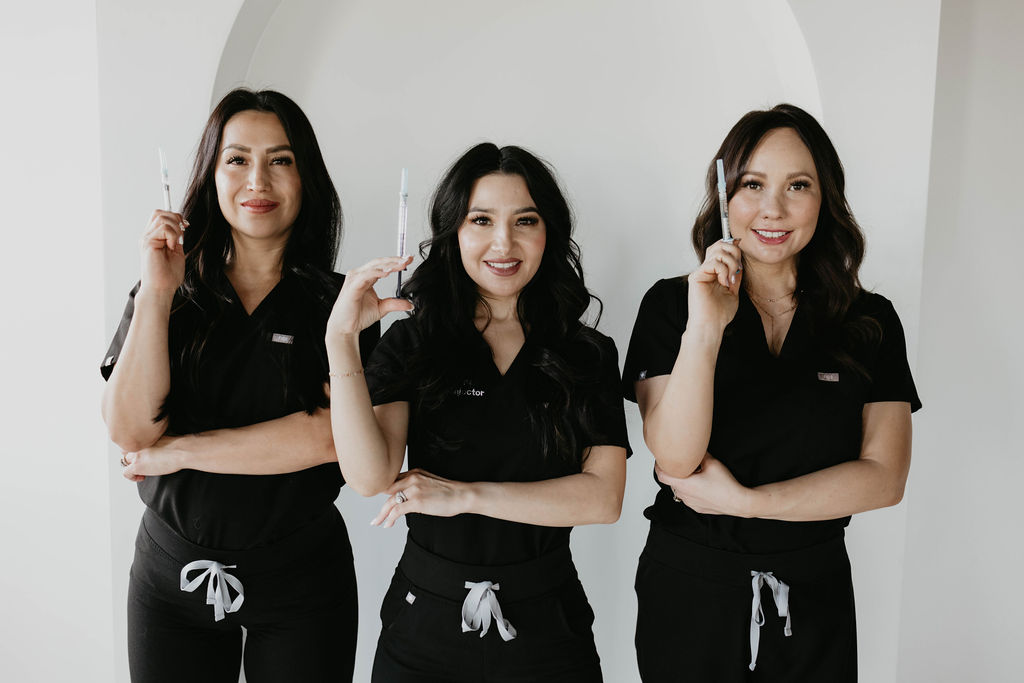Professional skincare specialists in black uniforms demonstrating expertise in facial aesthetics and fillers.